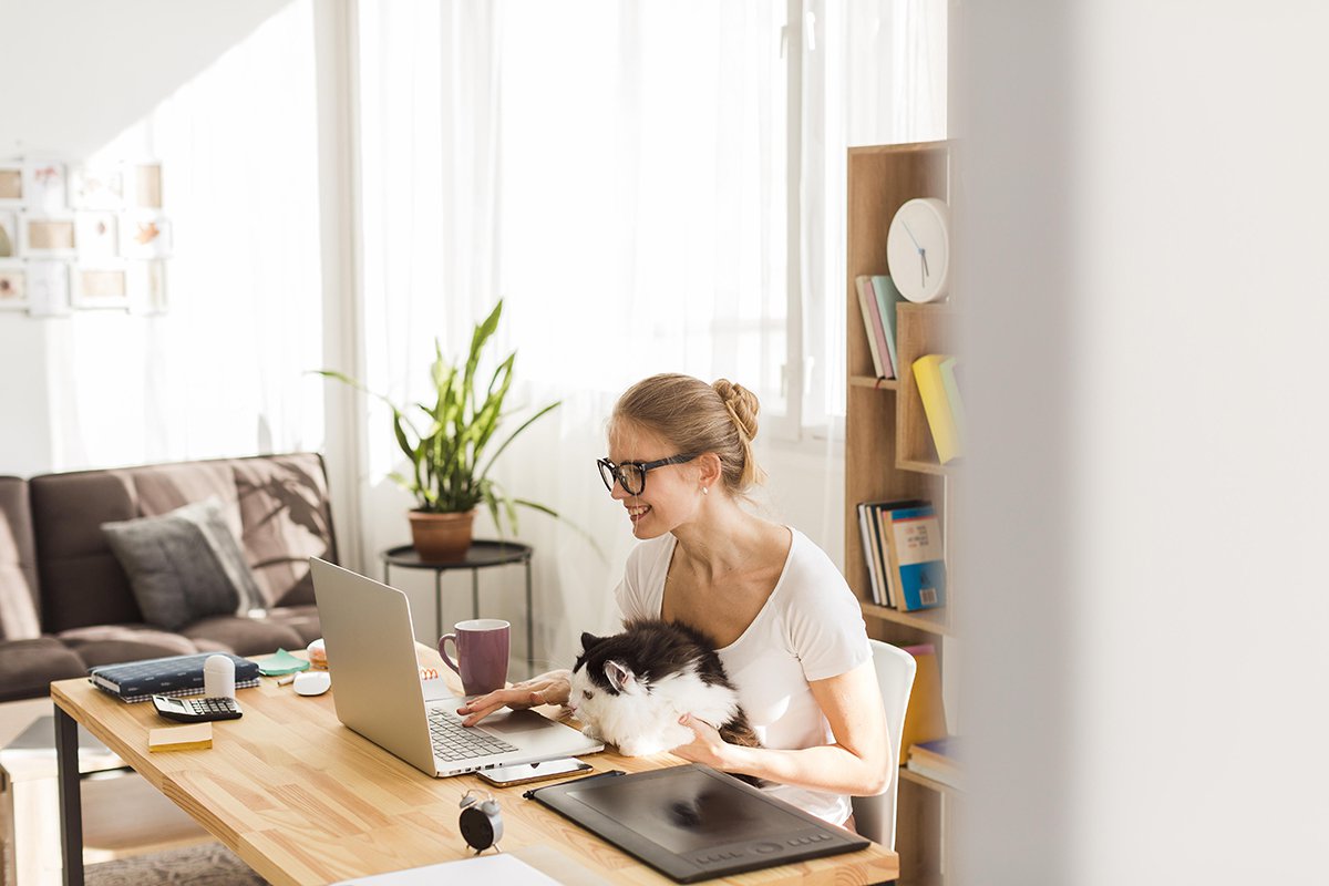 side-view-woman-desk-with-cat-working-from-home